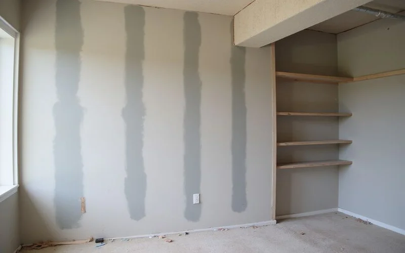 Finished basement wall with flush carbon fiber reinforcement beneath fresh paint